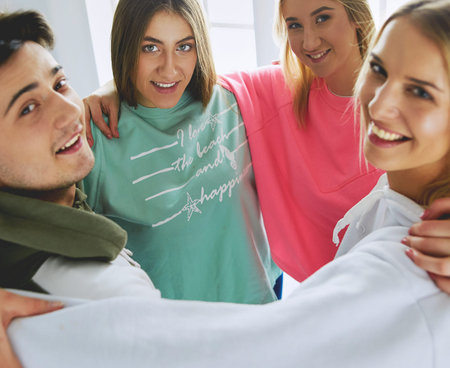 Happy smiling friends, group of young people standing and embracing together