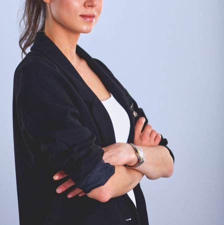 Young woman standing, isolated on gray background