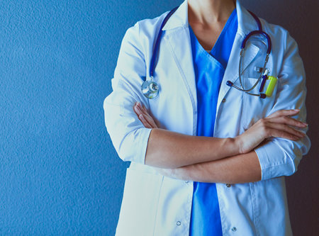 Portrait of young woman doctor with white coat standing in hospital.の写真素材