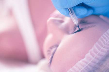 Permanent makeup for eyebrows. Closeup of beautiful woman with thick brows in beauty salon.の写真素材