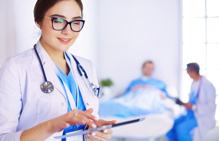 Female doctor using tablet computer in hospital lobbyの写真素材