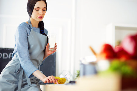 Woman baking at home following recipe on a tabletの写真素材