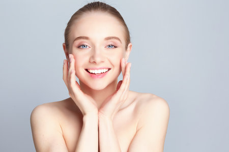 Portrait of beautiful woman with natural make up touching her face.の写真素材