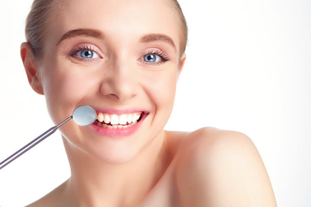 Woman teeth and a dentist mouth mirrorの写真素材