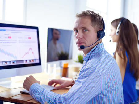 Attractive positive young businesspeople and colleagues in a call center officeの写真素材