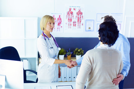 Female doctor handshaking a patients hand and smilingの写真素材