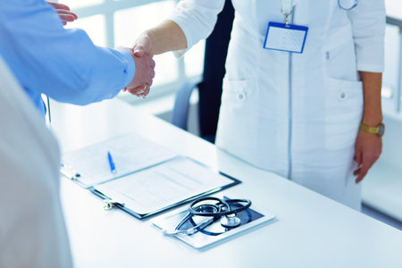 Female doctor handshaking a patients hand and smilingの写真素材