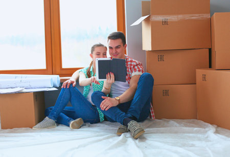 Couple moving in house sitting on the floor with ipad. Coupleの写真素材