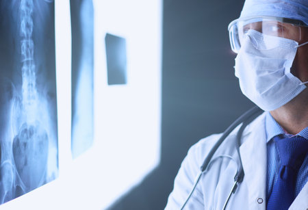 Young doctor looking X-Ray image on isolated white backgroundの写真素材