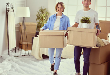 Couple holding boxes for moving the hands and looking inside boxの写真素材