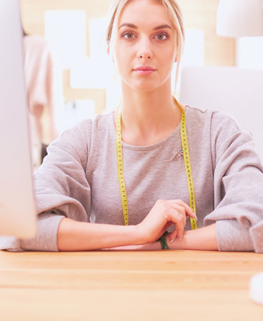 Fashion designer woman working in studio, sitting at thhe deskの写真素材