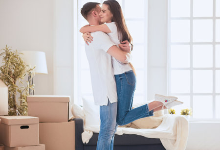 Cute couple unpacking cardboard boxes in their new homeの写真素材