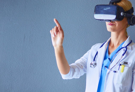 Female doctor wearing virtual reality glasses isolated on white background.の写真素材