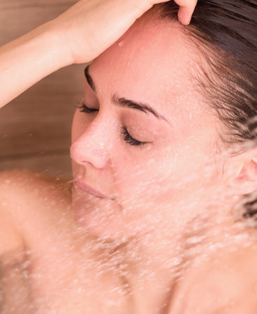 Young beautyful woman under shower in bathroom.の写真素材