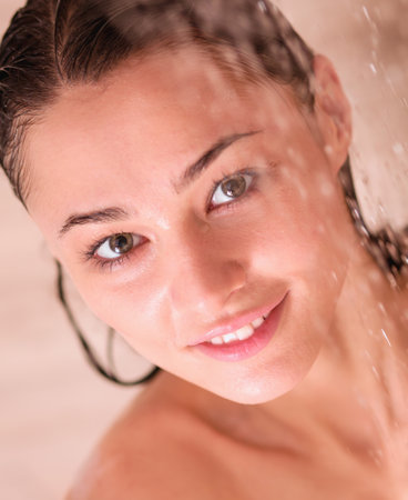Young beautyful woman under shower in bathroom.の写真素材