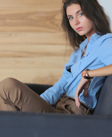 Portrait of happy young woman sitting on sofa. young womanの写真素材