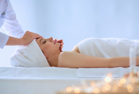Young woman lying on a massage table,relaxing with eyes closed. Woman. Spa salonの写真素材