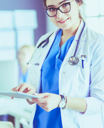 Female doctor using tablet computer in hospital lobbyの写真素材