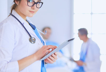 Female doctor using tablet computer in hospital lobbyの写真素材