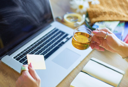 Young woman holding credit card and using laptop computer. Online shopping conceptの写真素材