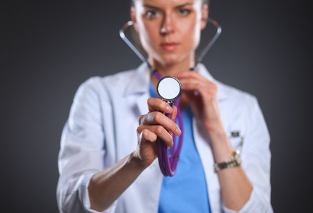 Female doctor with a stethoscope listening, isolated on grey backgroundの写真素材
