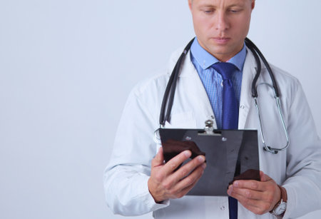 Male doctor standing with folder, isolated on white backgroundの写真素材