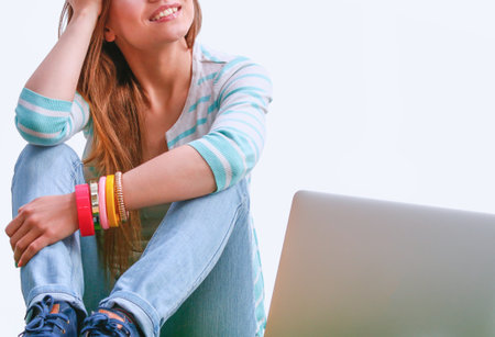 Young woman with laptop sitting on green grass . Portreit young womanの写真素材