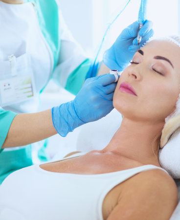 Permanent makeup for eyebrows. Closeup of beautiful woman with thick brows in beauty salon.の写真素材