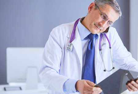 Male doctor writes notes on the clipboard in the hospitalの写真素材