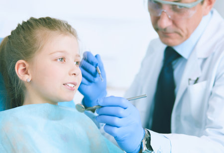 Little girl sitting in the dentists officeの写真素材