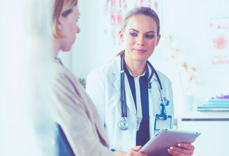 Doctor and patient discussing something while sitting at the table . Medicine and health care conceptの写真素材