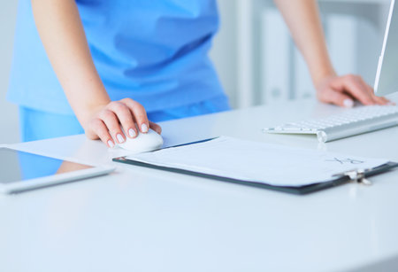 Portrait of a female doctor using her laptop computer at clinicの写真素材