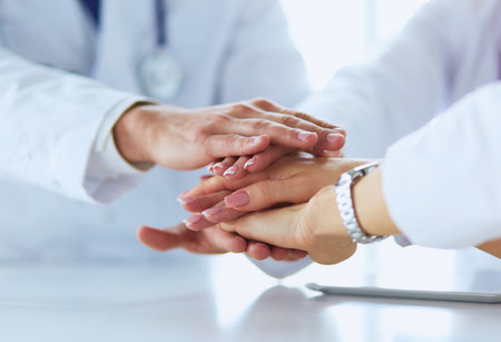 Team of doctors putting hands together, closeupの写真素材