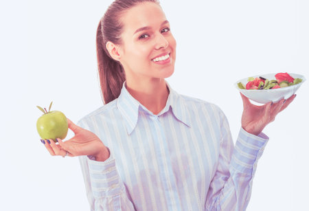 Portrait of a beautiful woman doctor holding a plate with fresh vegetables and green apple. Woman doctorの写真素材