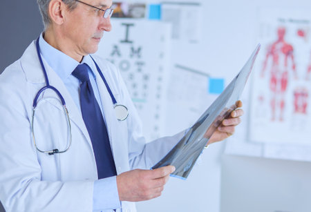 Male doctor writes notes on the clipboard in the hospitalの写真素材