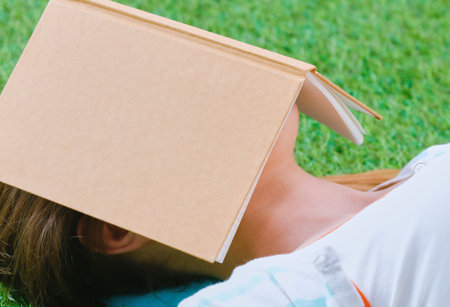 Young woman sitting on green grass . Portreit young womanの写真素材
