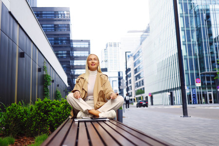 Calm business woman meditating in lotus outdoorsの写真素材