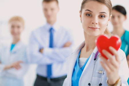 Female doctor with stethoscope holding heartの写真素材