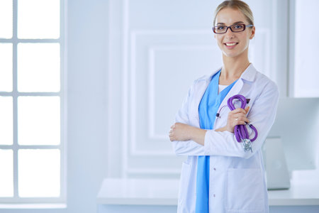 Cheerful happy doctor with crossed hands on blue backgroundの写真素材