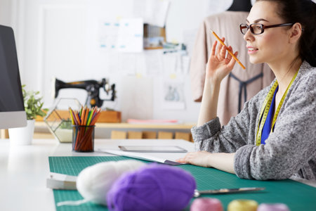 Fashion designers working in studio sitting on the desk.の写真素材