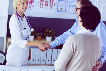 Female doctor handshaking a patients hand and smilingの写真素材