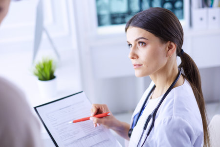 Beautiful female doctor explaining medical treatment to a patientの写真素材