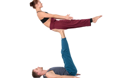 Young athletic couple practicing acroyoga. Balancing in pairの写真素材