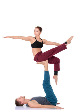 Young athletic couple practicing acroyoga. Balancing in pairの写真素材