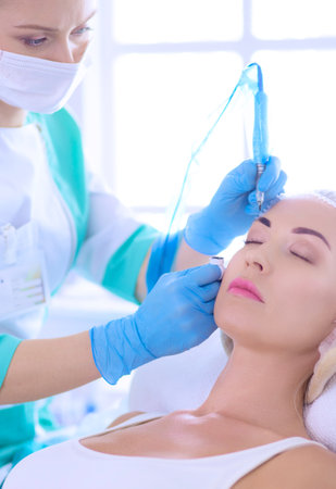 Permanent makeup for eyebrows. Closeup of beautiful woman with thick brows in beauty salonの写真素材