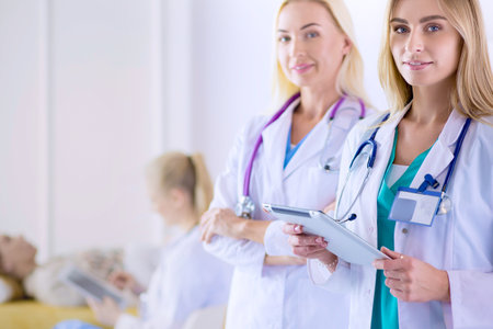 Portrait of three confident female doctors standing with arms crossed at the medical officeの写真素材
