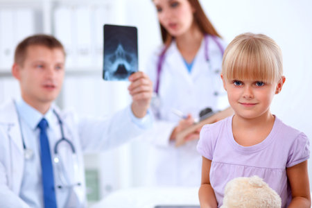 Female doctor examining child with stethoscope at surgeryの写真素材