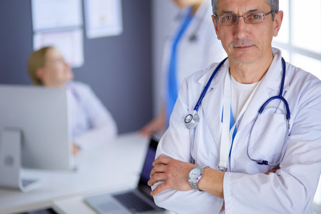 Portrait of a smiling doctor in his bright officeの写真素材