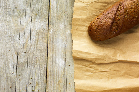 A loaf of Bread packed in paper on wooden table.の写真素材