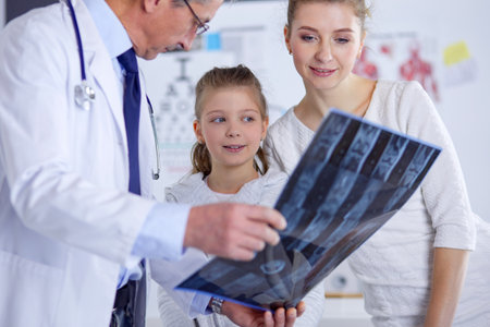 Little girl with her mother at a doctor on consultationの写真素材
